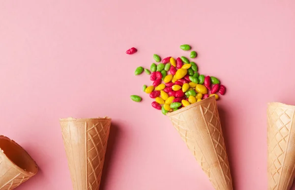 Cones de waffle e polvilhas na superfície rosa — Fotografia de Stock