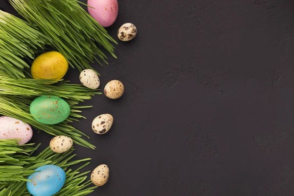 Bunte Ostereier im grünen Gras auf grauem Hintergrund — Stockfoto