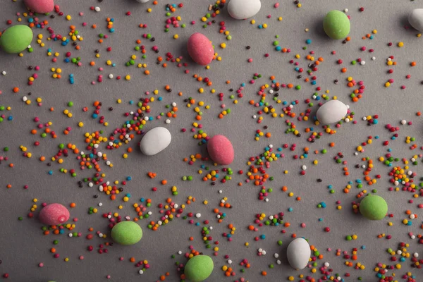 Vários doces e polvilhas coloridas na mesa cinza — Fotografia de Stock