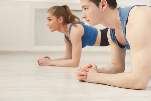 Treinamento de prancha de casal fitness dentro de casa — Fotografia de Stock