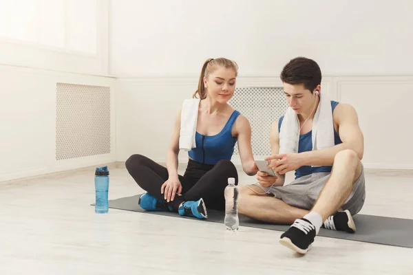 Fit couple with smartphone listening to music — Stock Photo, Image
