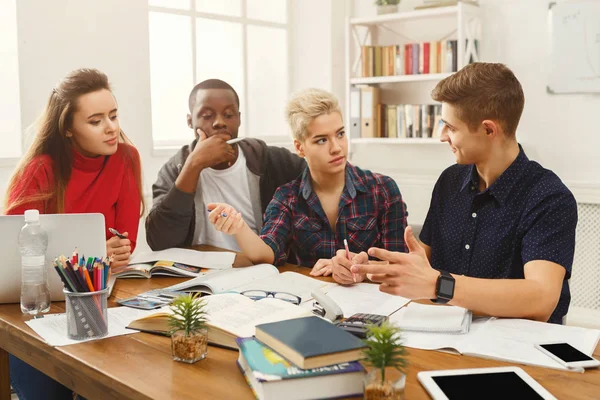 Grupo de estudiantes diversos que estudian en la mesa de madera — Foto de Stock