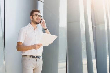 Bir telefon görüşmesi açık havada yapma işadamı gülümseyen