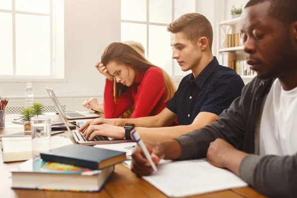 Gruppe verschiedener Studenten, die am Holztisch lernen — Stockfoto