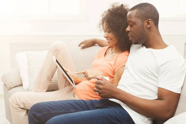 Pareja negra haciendo uso de la tableta digital en casa —  Fotos de Stock