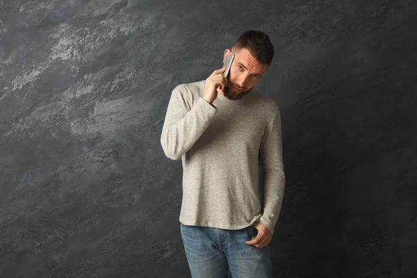 Hombre serio hablando por teléfono inteligente en el estudio —  Fotos de Stock