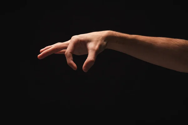 Mannenhand oppakken van iets, knipsel op zwart — Stockfoto