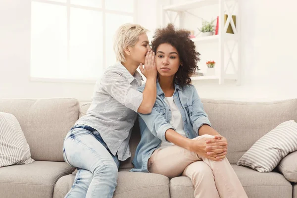 Giovane donna dicendo al suo amico alcuni segreti — Foto Stock