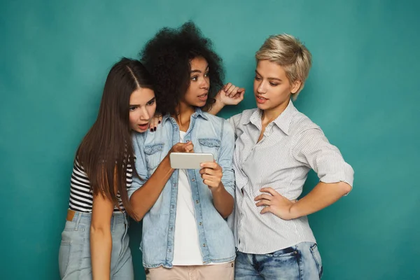 Tre kvinnliga vänner som använder smartphones — Stockfoto