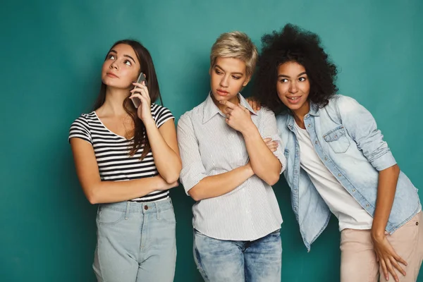 Meninas ouvindo seu amigo telefone celular falar — Fotografia de Stock