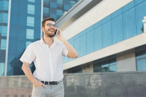 Joven hombre de negocios feliz haciendo una llamada al aire libre — Foto de Stock