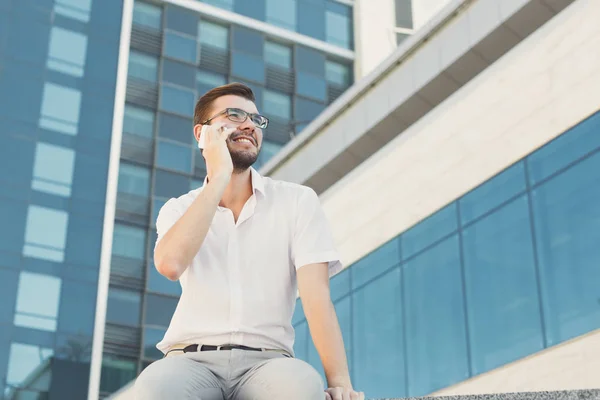 Sorrindo jovem empresário fazendo um telefonema ao ar livre — Fotografia de Stock