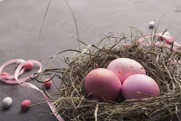 复活节背景。灰石表面巢中的彩色蛋 — 图库照片
