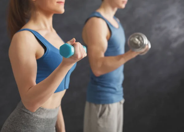 Fitness couple making exercise with dumbbells — Stock Photo, Image