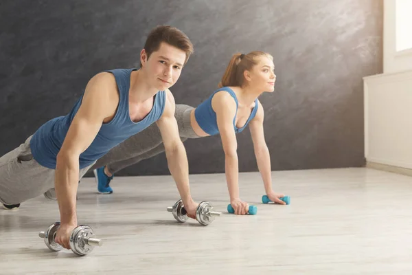 Couple making plank or push ups exercise indoors — Stock Photo, Image