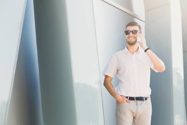 Bir telefon görüşmesi açık havada yapma işadamı gülümseyen