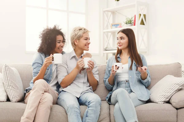 Tre unga kvinnliga vänner med kaffe chatta hemma — Stockfoto