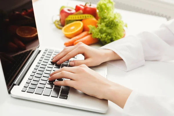 Kvinnliga nutritionist arbetar på bärbar dator — Stockfoto