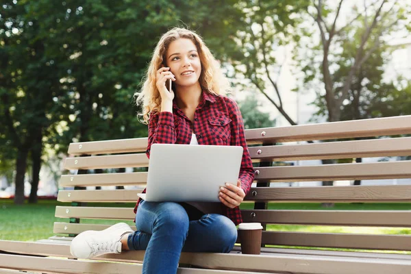 Sonriente joven hablando por teléfono al aire libre — Foto de Stock