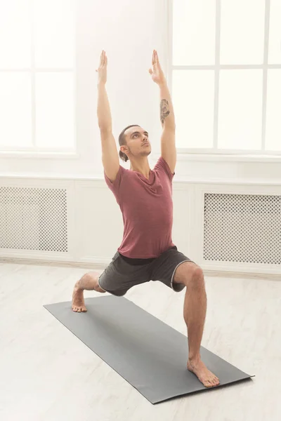 Hombre estirando las manos y las piernas en el gimnasio — Foto de Stock