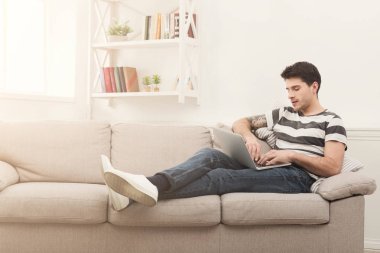 Genç adam evde online üstünde laptop mesajlaşma