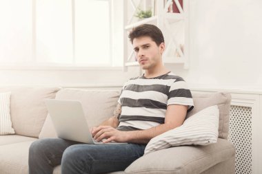 Genç adam evde online üstünde laptop mesajlaşma