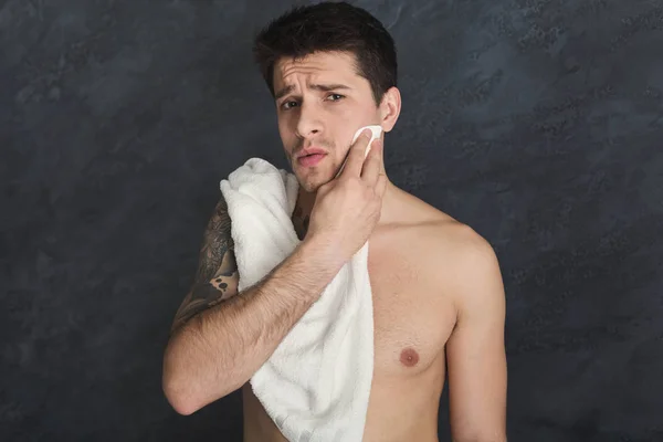 Bello giovane tatuato uomo toccare il suo viso — Foto Stock