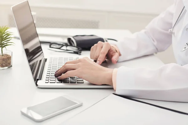 Ärztin tippt in Großaufnahme auf Laptop — Stockfoto