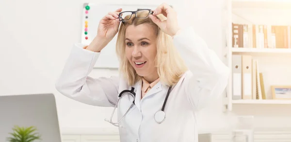 Medico sorpreso con gli occhiali seduti sul desktop — Foto Stock