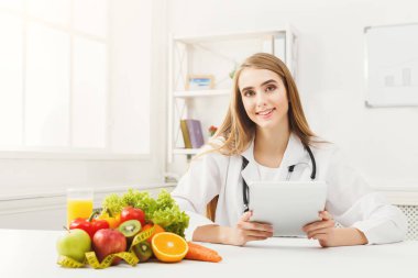 Dijital tablet üzerinde çalışan kadın beslenme uzmanı