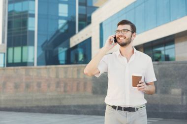 Açık havada bir telefon görüşmesi genç gülümseyen iş adamı