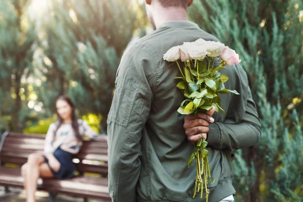Vista posterior del hombre sosteniendo flores para novia —  Fotos de Stock
