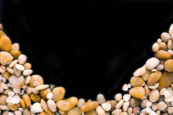 Cáscaras de mar y guijarros sobre fondo negro, piedras marinas naturales — Foto de Stock