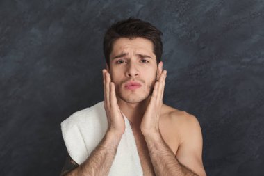 Yakışıklı genç dövmeli adam yüzünü dokunaklı