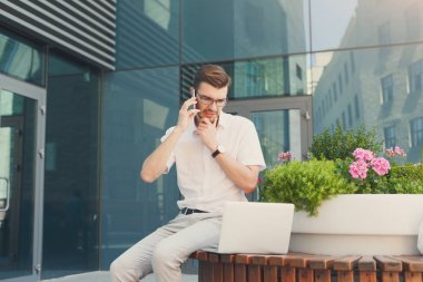 Açık havada çalışan dalgın emin iş adamı