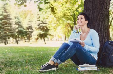 Shorthaired kız öğrenci açık havada yazma