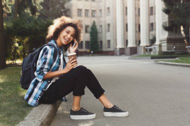 Genç öğrenci parkta smartphone cep telefonu ile konuşmak