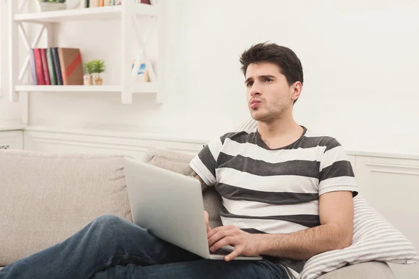 Jonge man thuis berichten online op laptop — Stockfoto