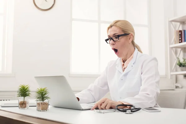 Medico scioccato guardando computer portatile — Foto Stock