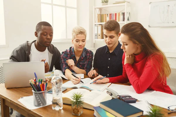 Grupo de estudantes diversos que estudam à mesa de madeira — Fotografia de Stock