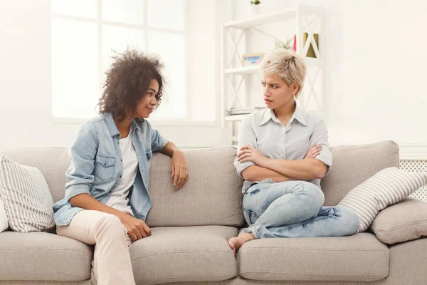 Two female friends sitting on sofa and arguing — Stock Photo, Image