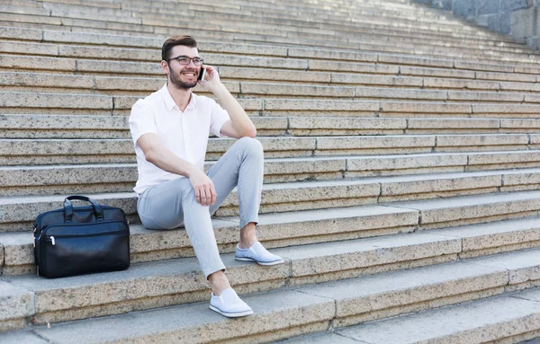 Joven feliz usando un teléfono en las escaleras —  Fotos de Stock