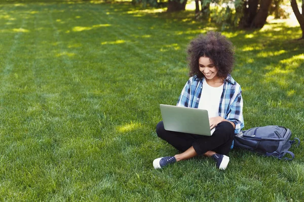 快乐的年轻黑人妇女使用笔记本电脑在公园 — 图库照片