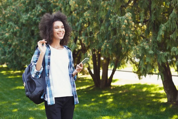 Mujer joven escuchando música al aire libre — Foto de Stock