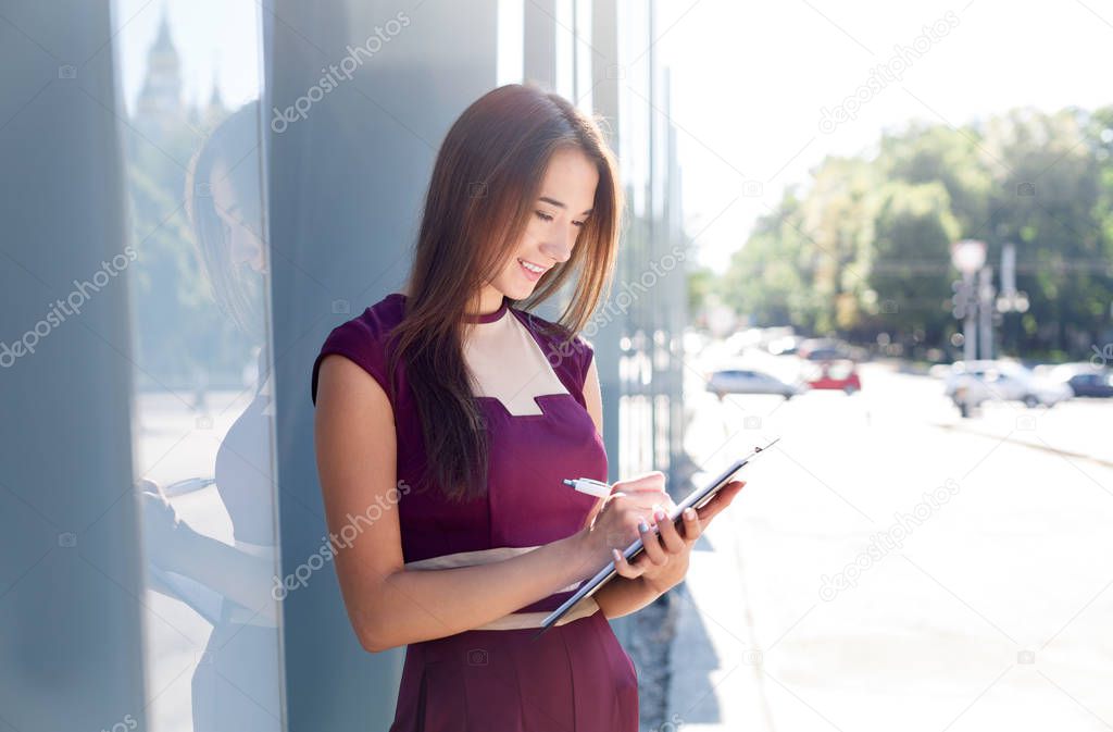 Happy businesswoman working with papers outdoors