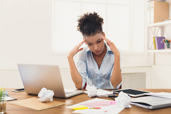 Frustrated business woman with headache at office