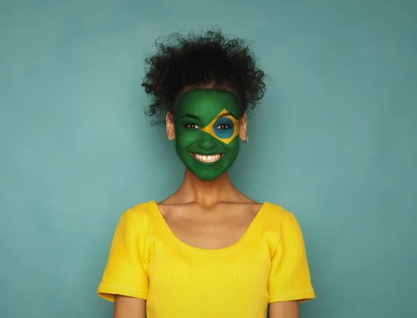 Giovane donna con bandiera brasiliana dipinta sul viso — Foto Stock