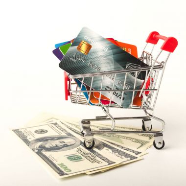 Para Doları nakit banknot ve alışveriş sepeti içinde kredi kartları