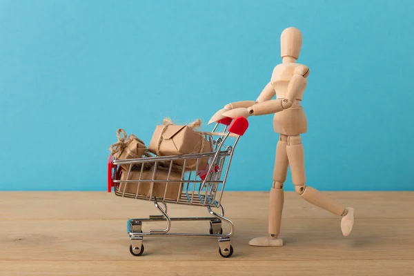ショッピングカートのミニチュア木製のマネキン — ストック写真