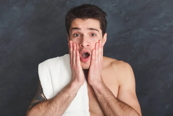 Surprised young tattooed man touching his face — Stock Photo, Image